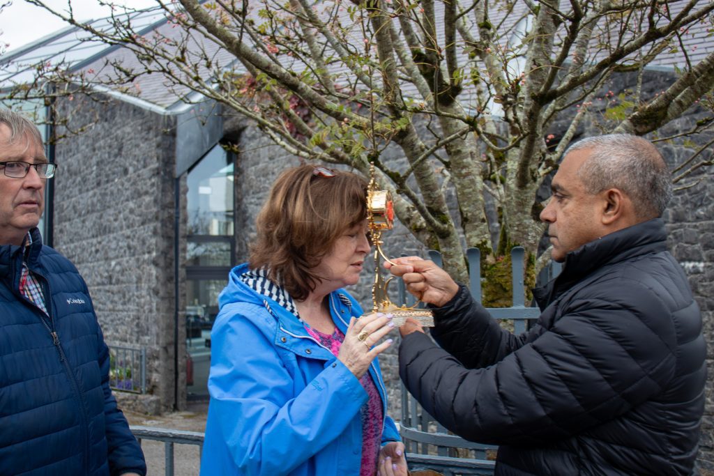 3. A pilgrim receives a blessing from Msgr Figueiredo with the relic of Blessed Carlo Acutis at Knock Shrine